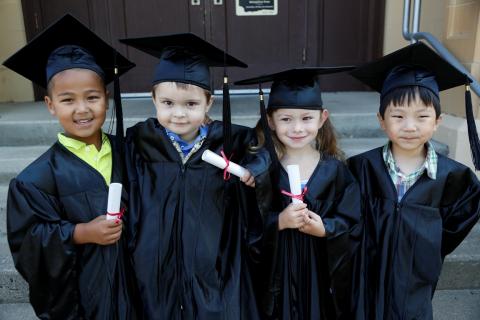 Kindergarten children in grad caps and gowns